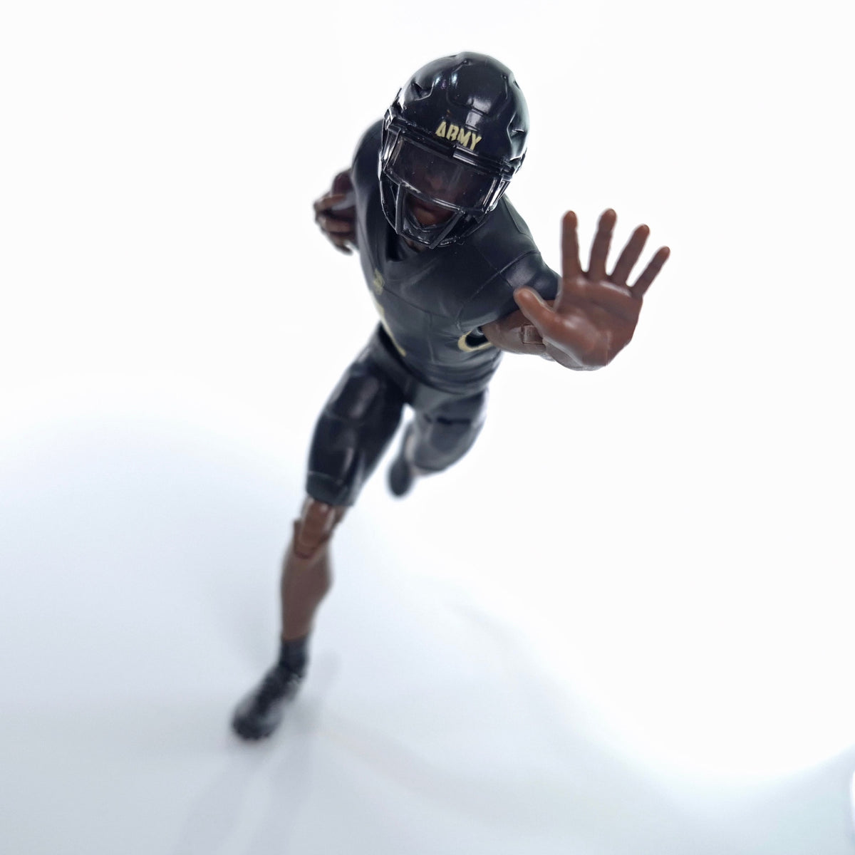 Collegiate Legends Army football action figure in black and gold uniform with helmet in a dynamic running pose