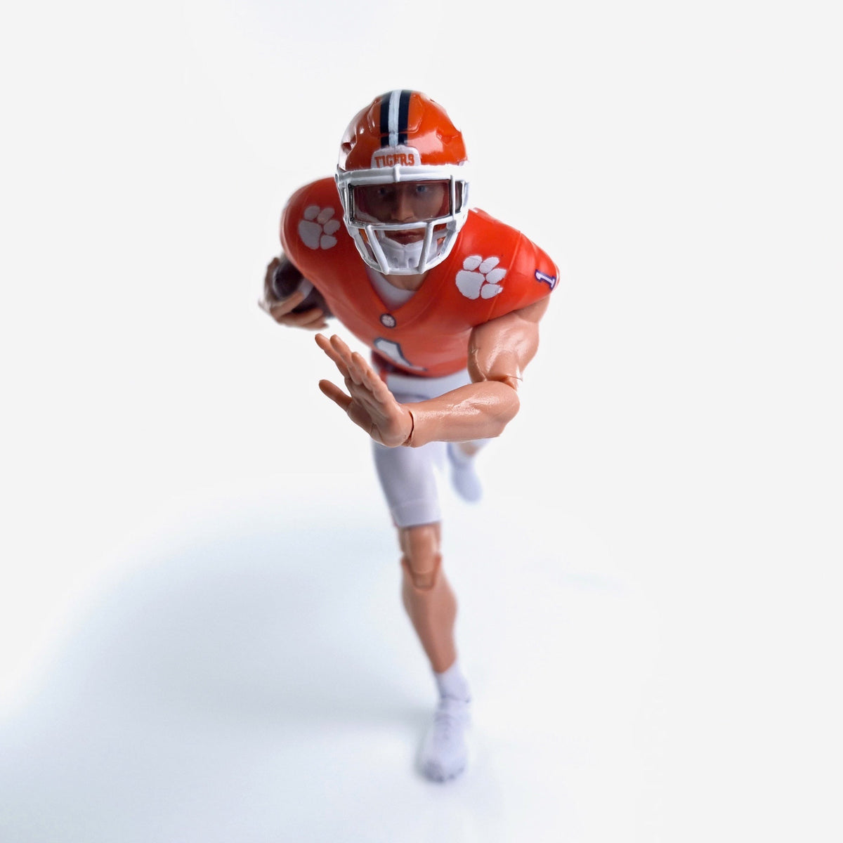 Collegiate Legends Clemson football action figure in orange jersey and helmet running with a football