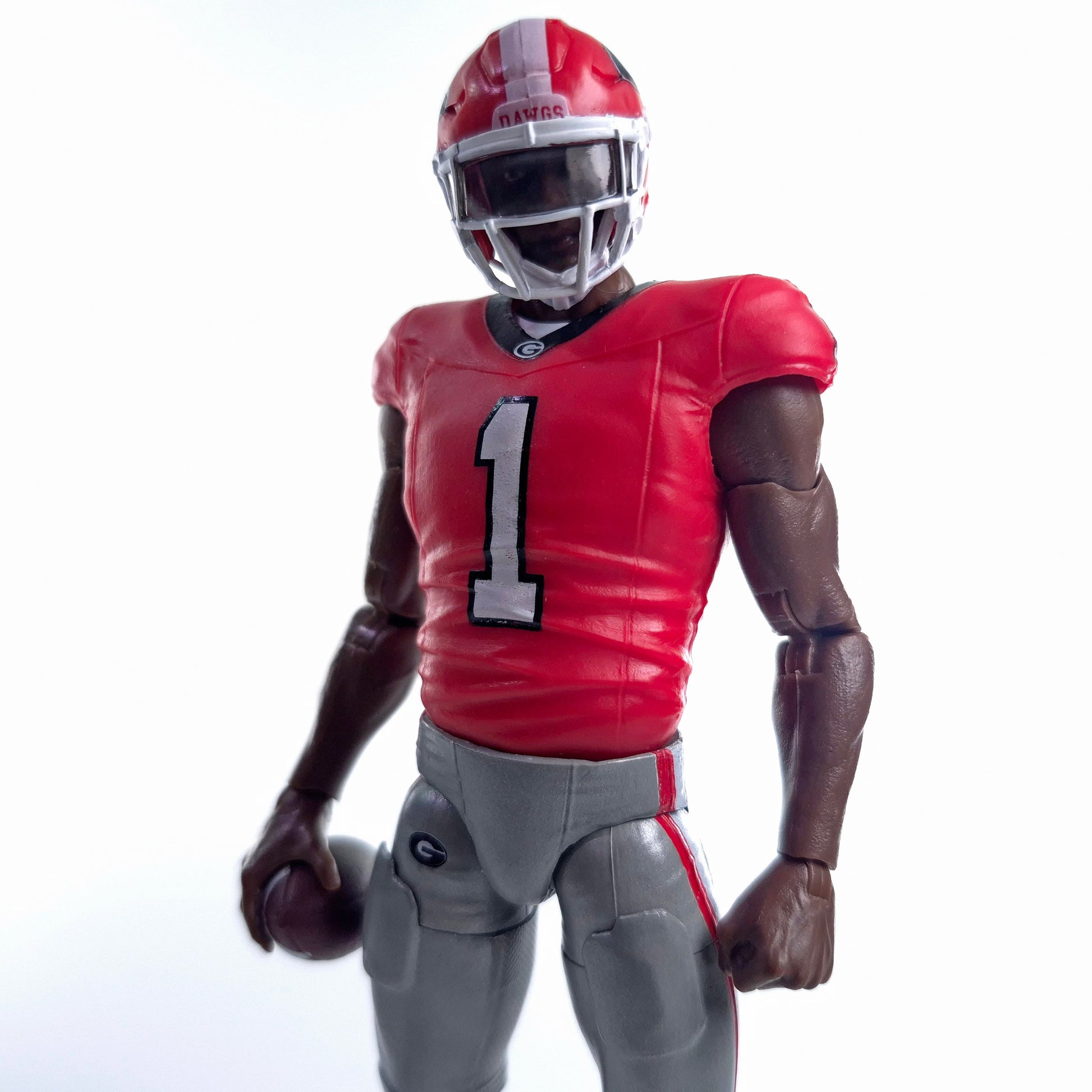 Collegiate Legends Georgia Bulldogs #1 football action figure in red jersey and grey pants holding a football
