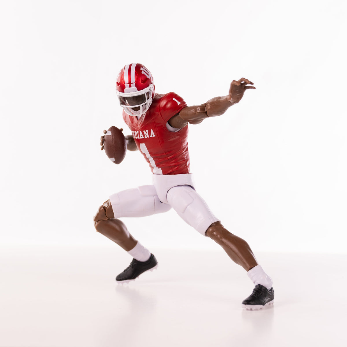 Collegiate Legends Indiana football action figure with dark skin tone in a dynamic throwing pose with a football.