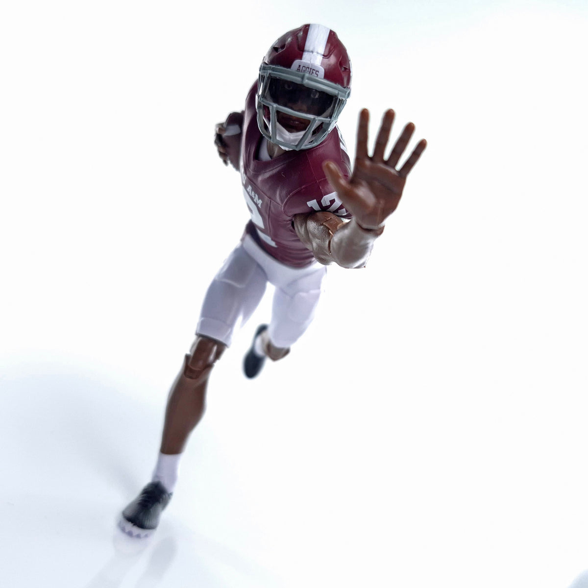 Collegiate Legends Texas A&M football action figure in maroon and white uniform reaching forward in a running pose